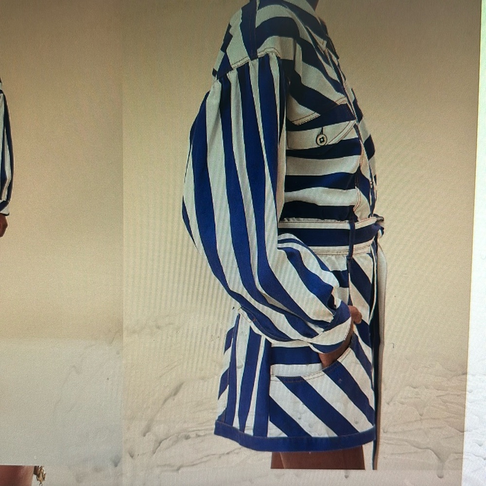 Blue and white striped romper has collar, buttons, pockets and long sleeves.